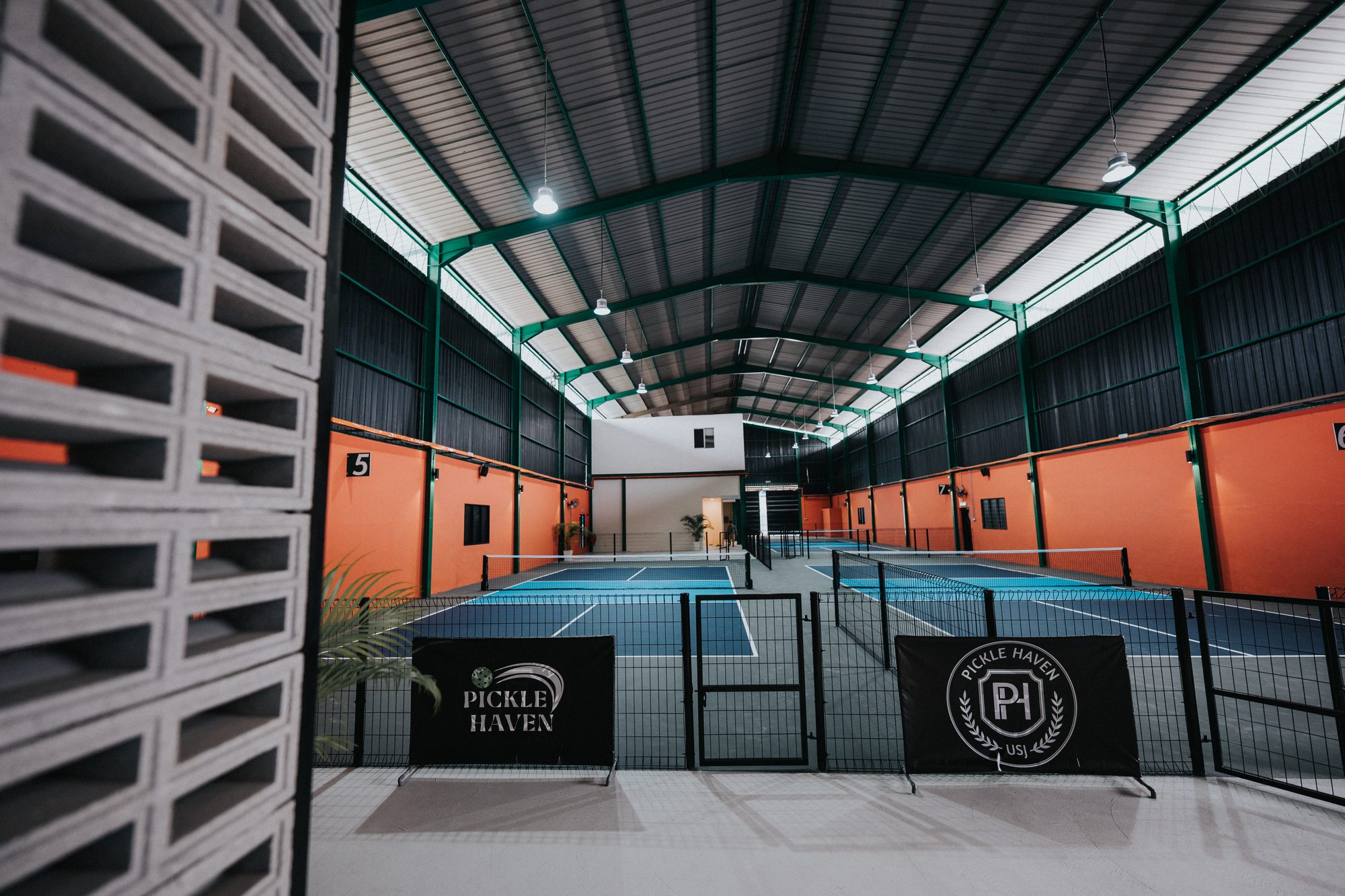 Pickle Haven indoor hall with green steel trusses